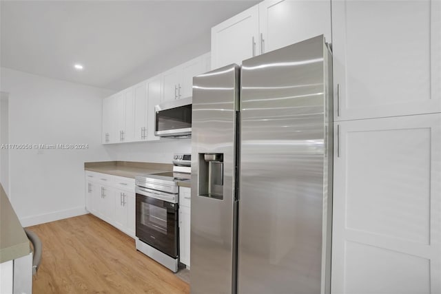 kitchen featuring white cabinets, light wood-type flooring, and appliances with stainless steel finishes