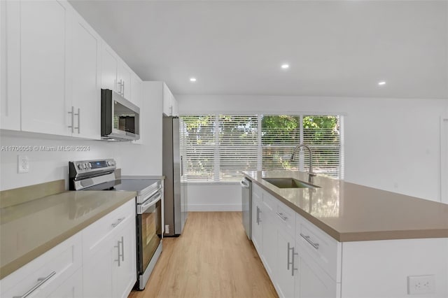 kitchen with appliances with stainless steel finishes, sink, a center island with sink, light hardwood / wood-style flooring, and white cabinetry