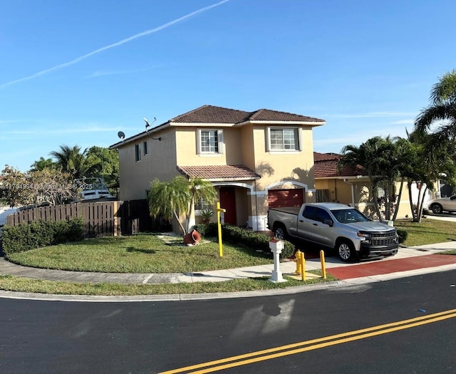 mediterranean / spanish-style home featuring a front yard and a garage