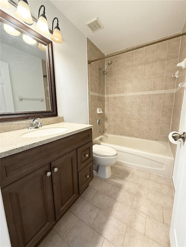 full bathroom featuring vanity, tiled shower / bath combo, and toilet