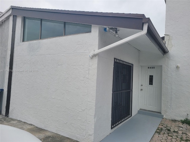 property entrance with stucco siding