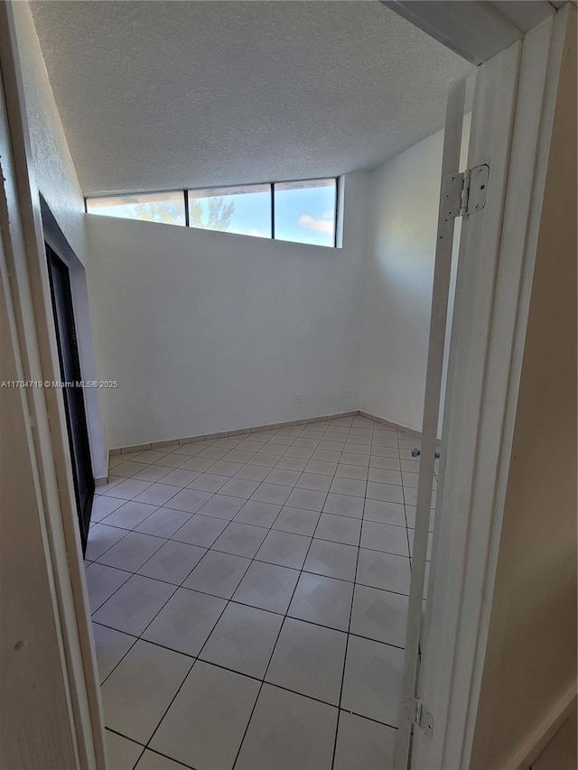 unfurnished room featuring light tile patterned flooring and a textured ceiling