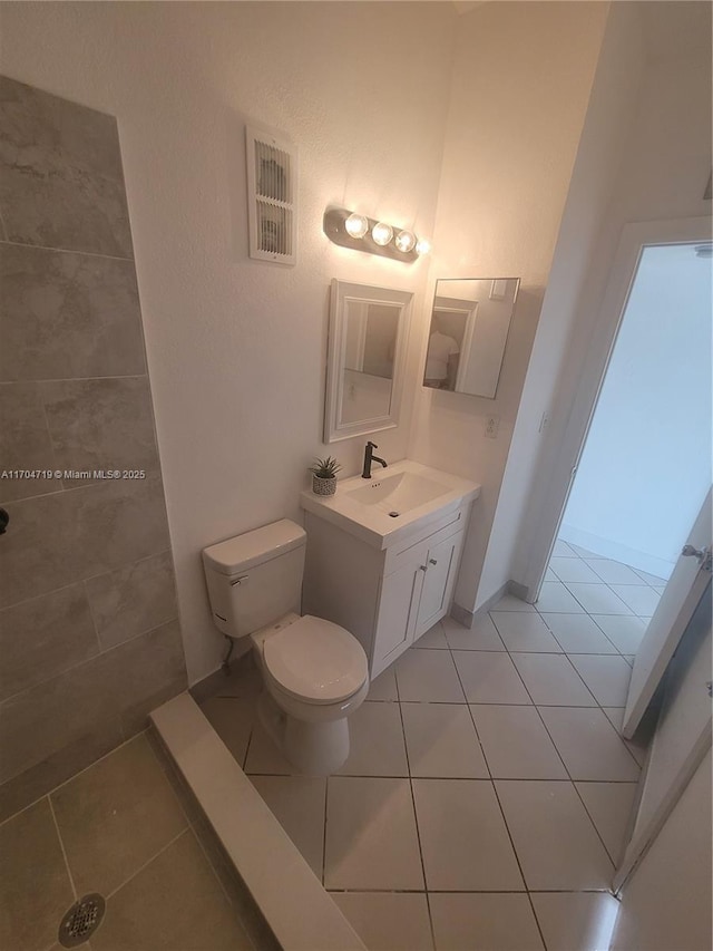 bathroom featuring toilet, visible vents, vanity, and tile patterned floors