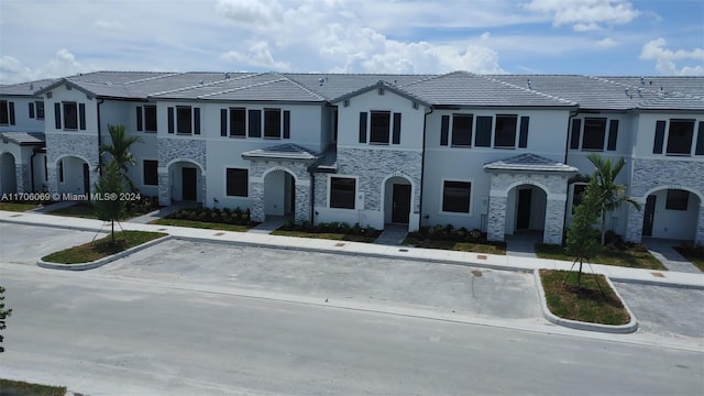 13313 SW 286th Ter Unit 13313, Homestead, FL 33033 - view of property with stone siding, stucco siding, and uncovered parking