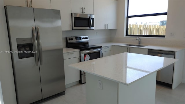 kitchen featuring white cabinets, a kitchen island, sink, and appliances with stainless steel finishes