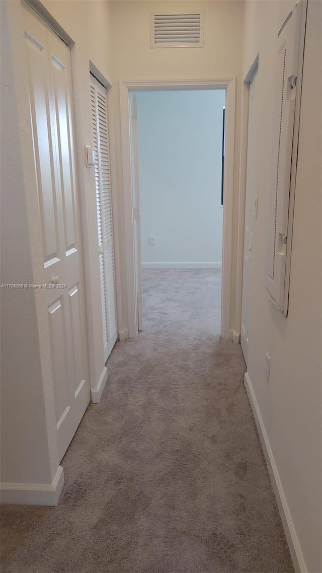 corridor featuring light colored carpet