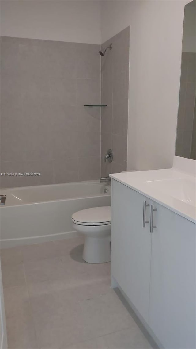 full bathroom featuring tile patterned flooring, vanity, toilet, and tiled shower / bath combo