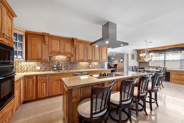 kitchen featuring sink, an island with sink, pendant lighting, island range hood, and light tile patterned floors