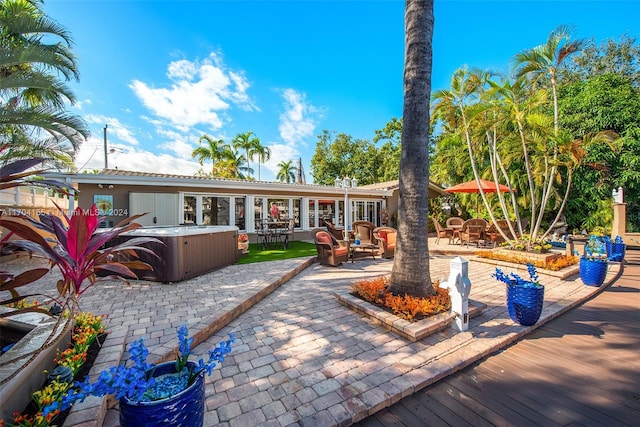 rear view of house with a patio and a hot tub