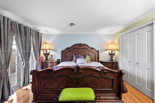 bedroom featuring a closet, light hardwood / wood-style floors, and ornamental molding