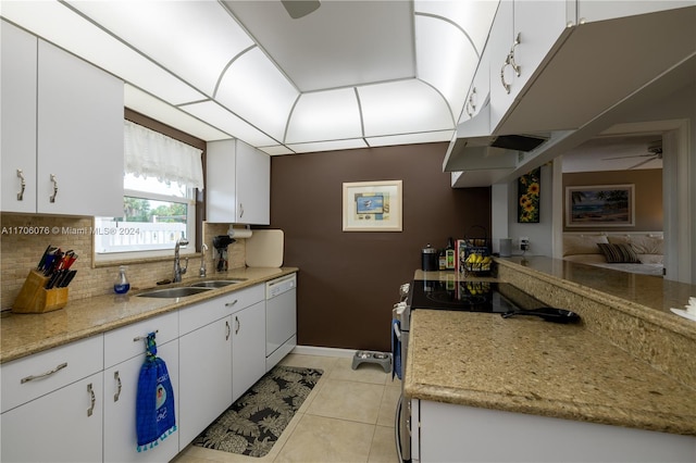 kitchen featuring white cabinets, dishwasher, light tile patterned floors, and sink