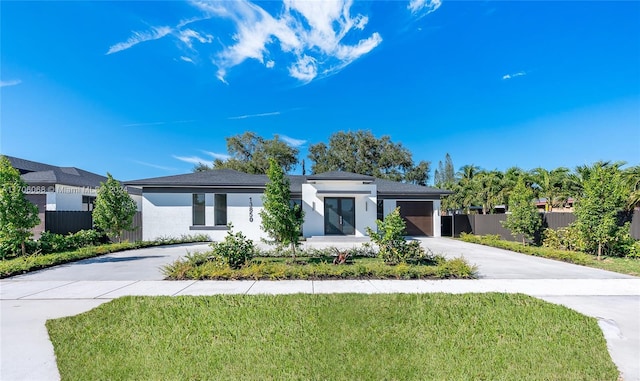 view of front of property featuring a garage and a front lawn