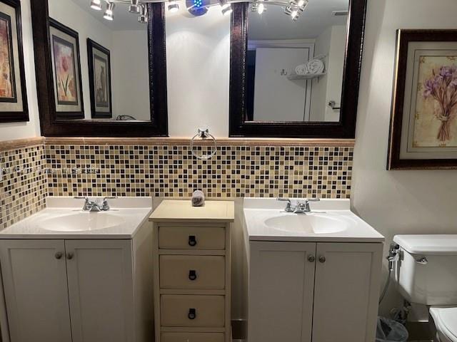 bathroom with decorative backsplash, vanity, and toilet