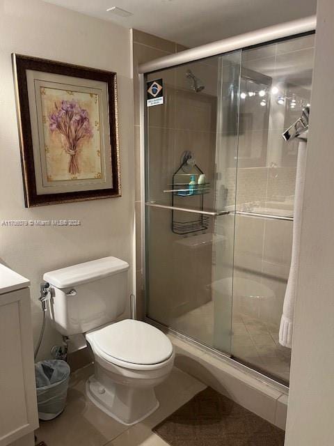 bathroom with tile patterned floors, toilet, vanity, and walk in shower