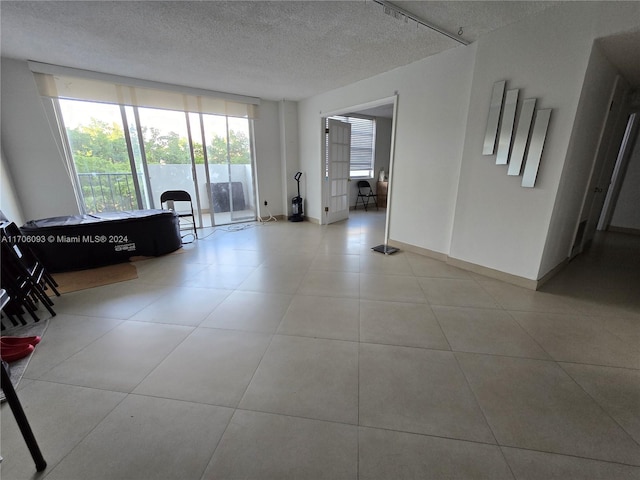 spare room featuring light tile patterned floors and a textured ceiling