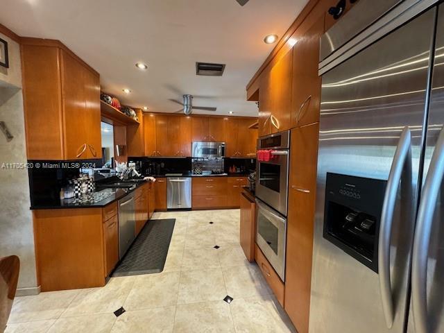 kitchen featuring decorative backsplash, ceiling fan, light tile patterned flooring, and stainless steel appliances