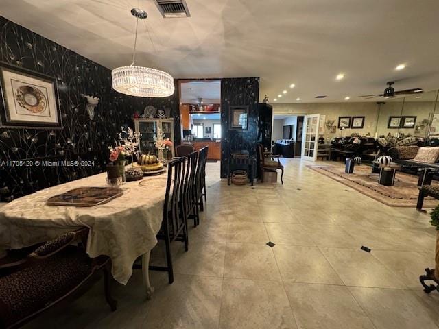 dining area featuring ceiling fan with notable chandelier