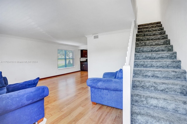 staircase featuring hardwood / wood-style floors and crown molding