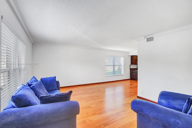 living room featuring ornamental molding and light hardwood / wood-style flooring