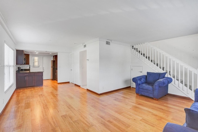 unfurnished living room with light hardwood / wood-style floors and ornamental molding