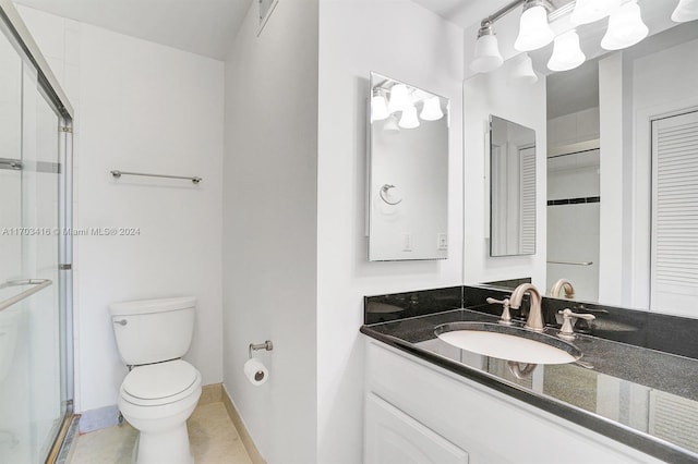 bathroom with tile patterned flooring, vanity, toilet, and a shower with door