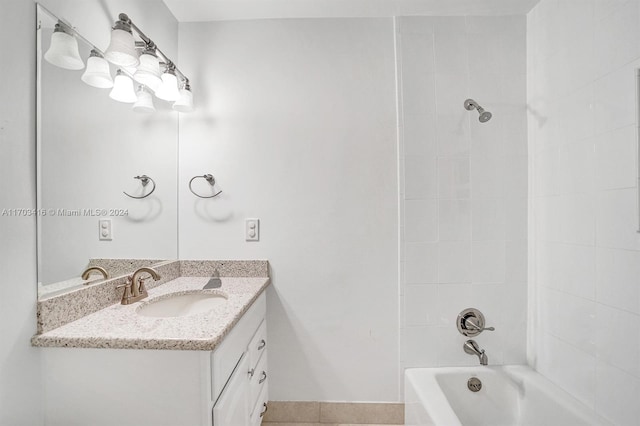 bathroom featuring tile patterned flooring, vanity, and tiled shower / bath