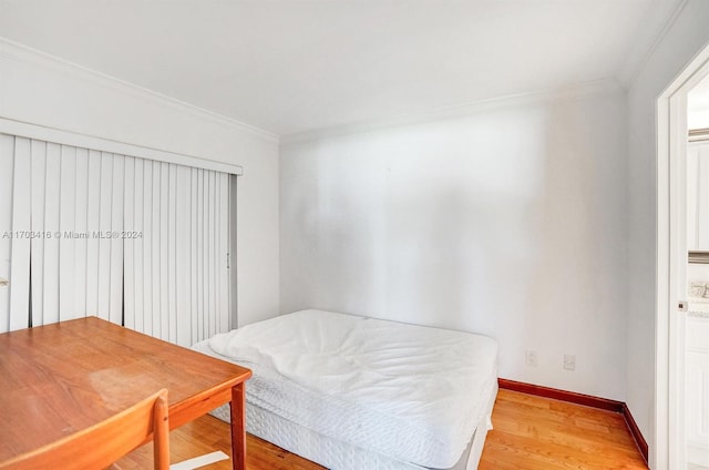 bedroom with light wood-type flooring and crown molding