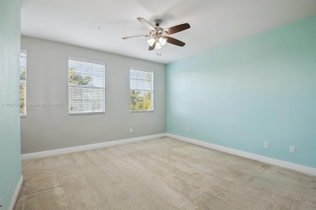 spare room with light carpet, ceiling fan, and baseboards