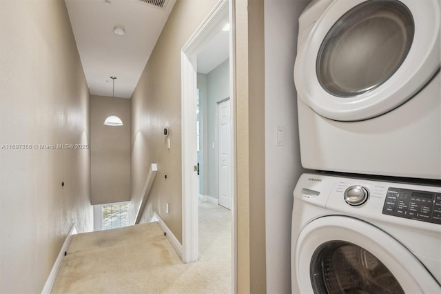 washroom with baseboards, laundry area, carpet, and stacked washer / drying machine