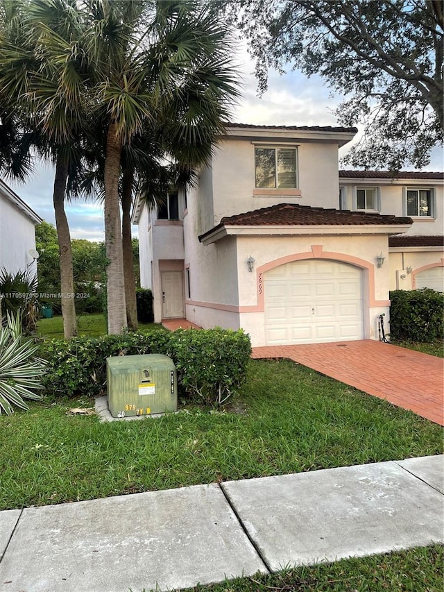 view of front of property featuring a garage and a front lawn