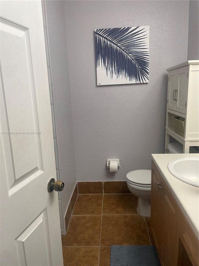 bathroom with tile patterned flooring, vanity, and toilet