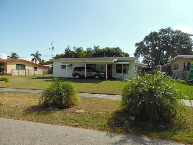 ranch-style home featuring a front yard and a carport