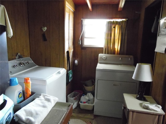 washroom with washing machine and dryer, wood walls, and hardwood / wood-style floors