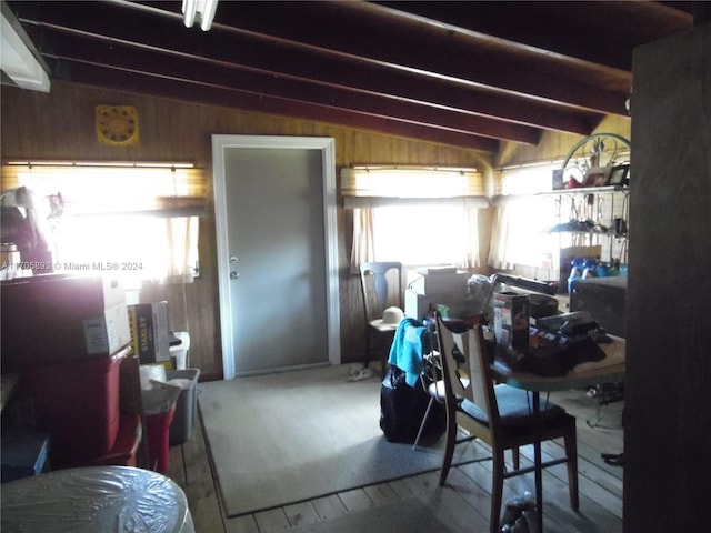 interior space with hardwood / wood-style floors, vaulted ceiling with beams, and wooden walls