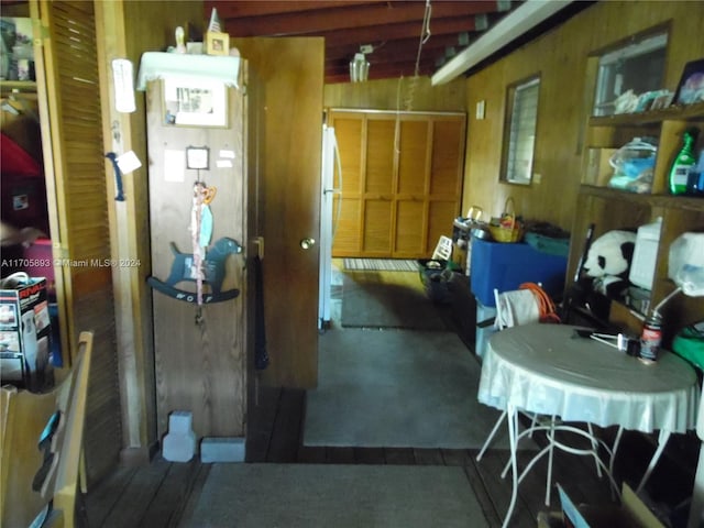 interior space featuring white refrigerator and wooden walls