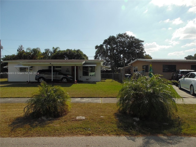 view of front facade with a front lawn and a carport