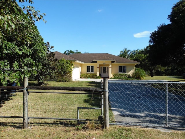 view of front of property with a garage and a front lawn