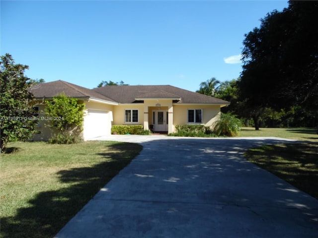 view of front of home with a front yard and a garage