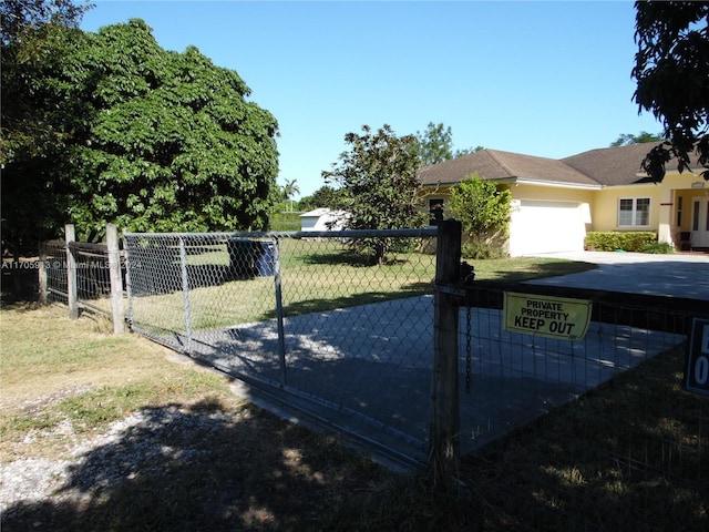 view of gate featuring a garage and a yard