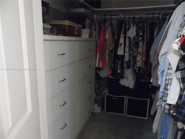 walk in closet featuring dark tile patterned floors