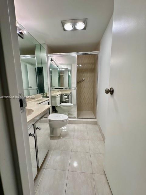 bathroom featuring vanity, a shower with shower door, tile patterned floors, and toilet