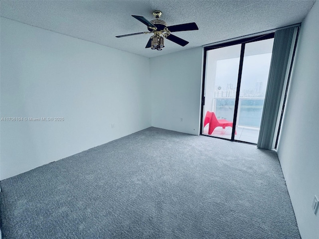 carpeted empty room with floor to ceiling windows, ceiling fan, and a textured ceiling