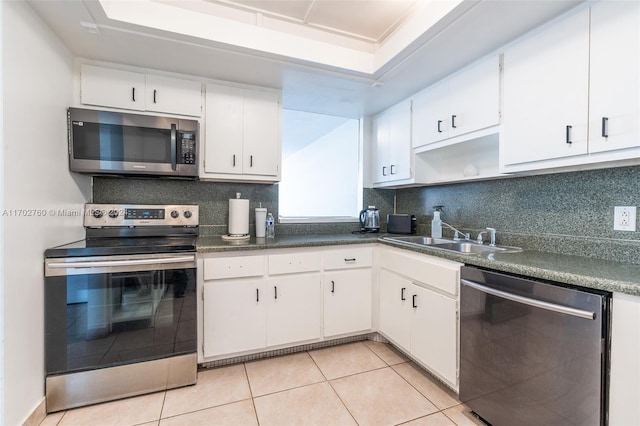 kitchen featuring sink, stainless steel appliances, white cabinets, decorative backsplash, and light tile patterned flooring