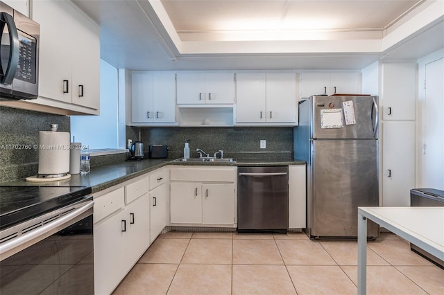 kitchen with a raised ceiling, white cabinetry, and appliances with stainless steel finishes