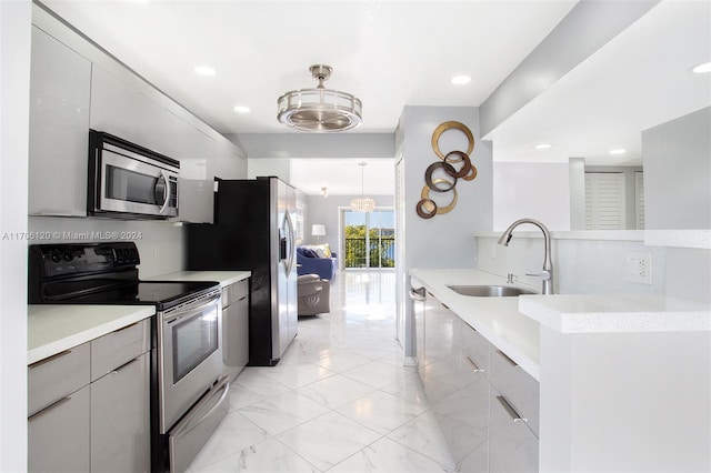 kitchen with range with electric stovetop, sink, pendant lighting, and an inviting chandelier