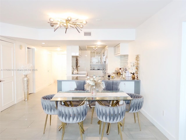 dining area with light tile patterned floors, an inviting chandelier, visible vents, and baseboards