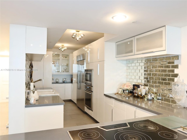 kitchen featuring a sink, glass insert cabinets, and white cabinets