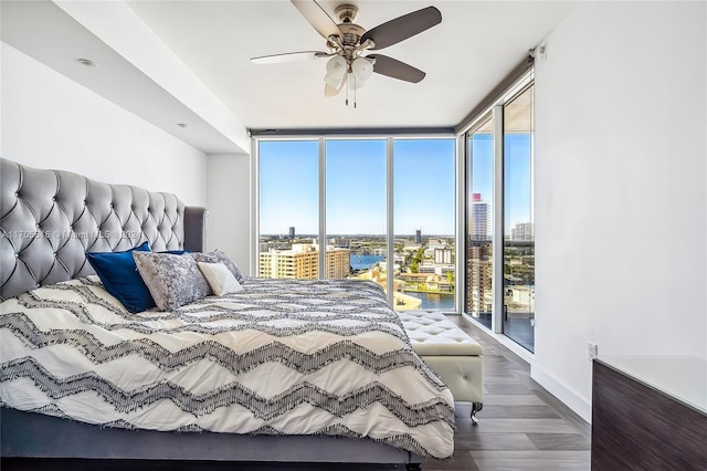 bedroom featuring access to exterior, ceiling fan, expansive windows, and hardwood / wood-style flooring