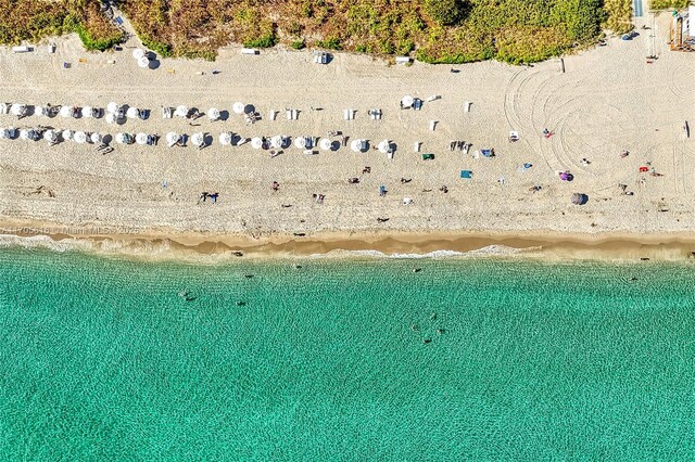 birds eye view of property with a water view and a view of the beach