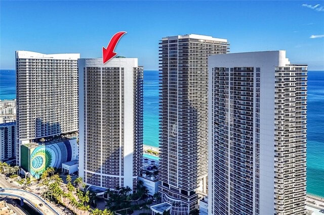 view of building exterior with a water view and a view of the beach